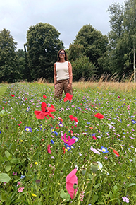 Portraitfoto von einer Frau im Blumenfeld